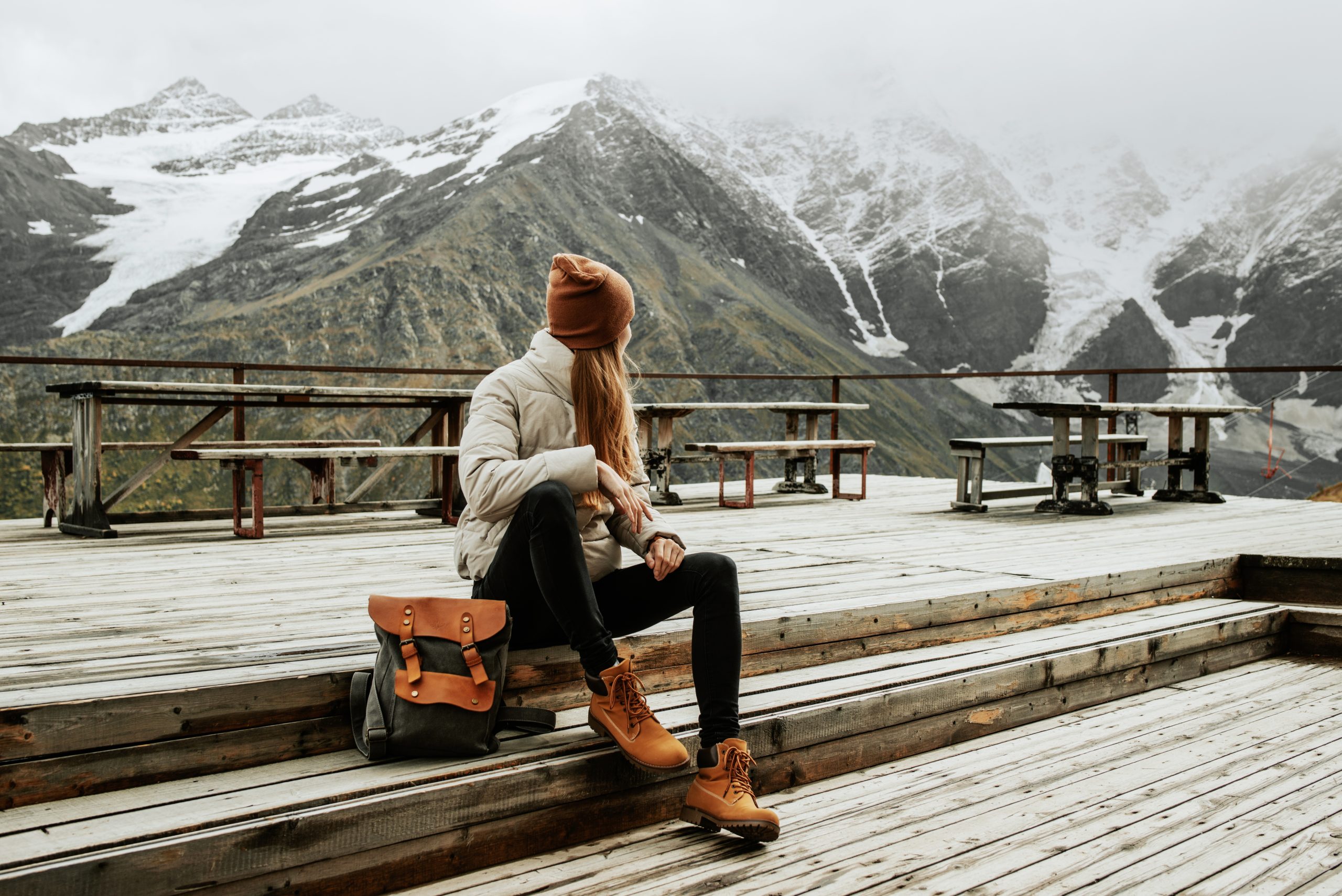 Woman with depression sitting outside looking at the mountain range